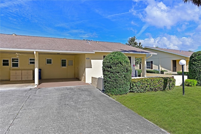 single story home with a front lawn, a shingled roof, and stucco siding