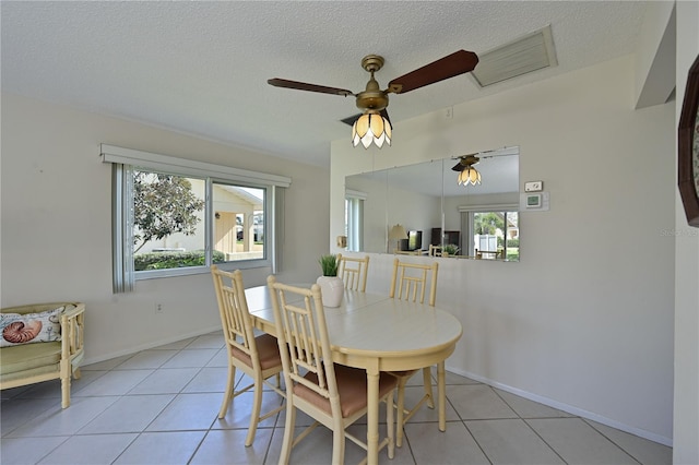 dining area with baseboards, visible vents, a textured ceiling, and light tile patterned flooring