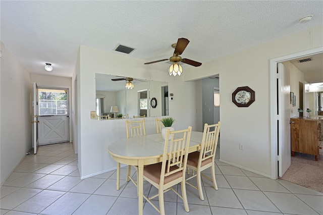 dining area featuring light tile patterned floors, visible vents, and a textured ceiling