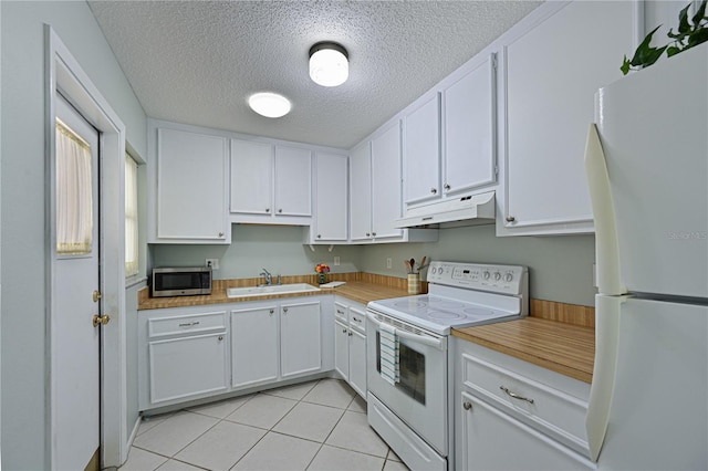 kitchen with white appliances, a sink, white cabinets, and under cabinet range hood