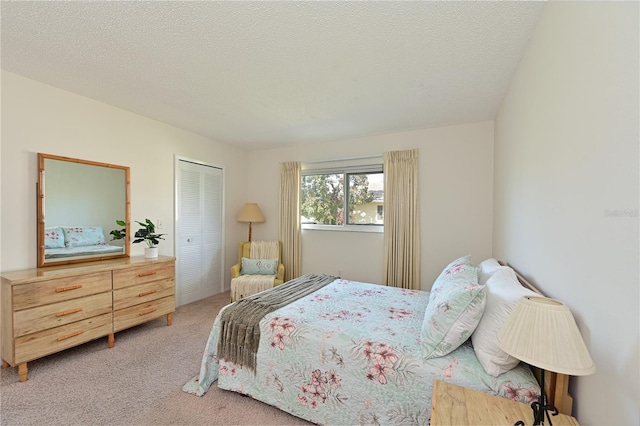 bedroom with light carpet, a closet, and a textured ceiling