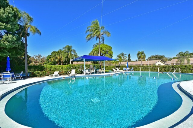 pool with a patio and fence