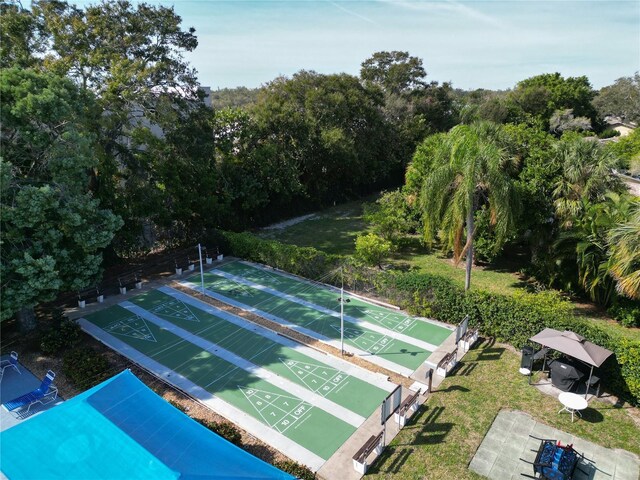 view of community featuring shuffleboard and a yard