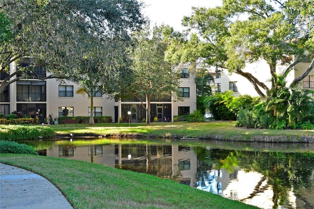 view of home's community with a water view and a lawn