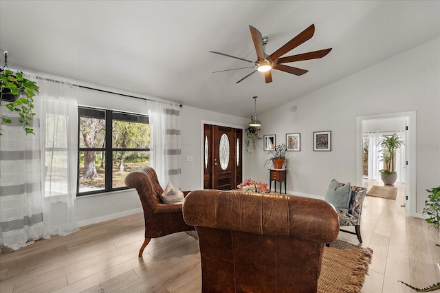 living area featuring ceiling fan, baseboards, lofted ceiling, and light wood-style floors