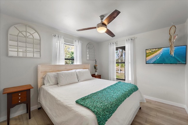 bedroom featuring wood finished floors, baseboards, and ceiling fan