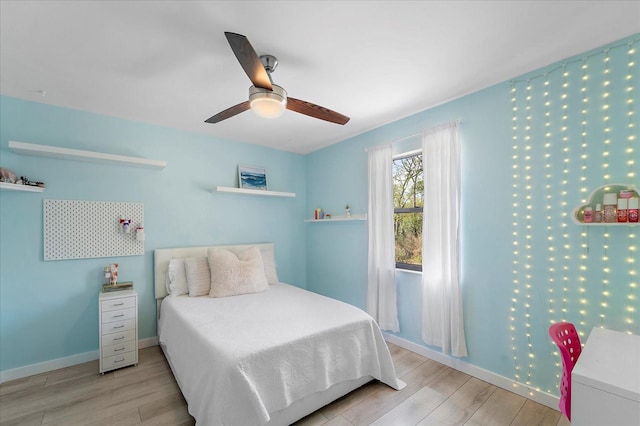 bedroom featuring a ceiling fan, baseboards, and wood finished floors