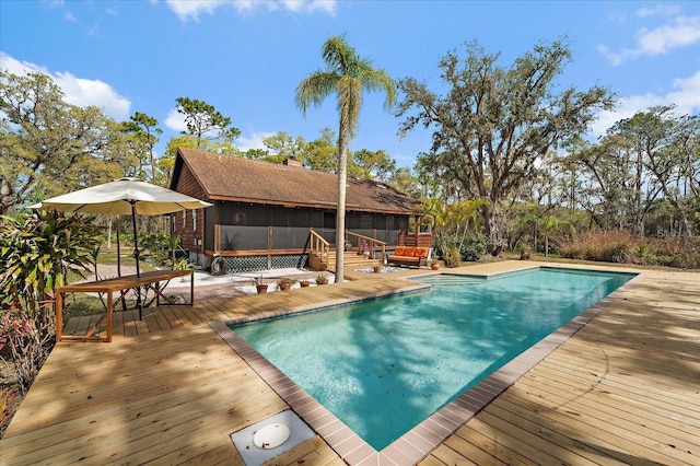 pool featuring a deck and a sunroom