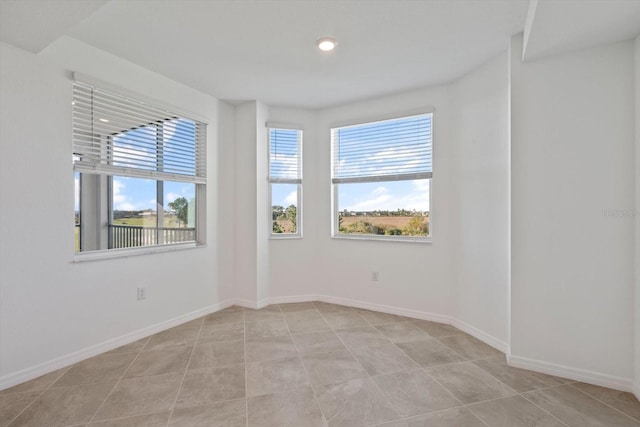 12180 Wellen Golf St Unit 302, Venice, FL 34293 - spare room featuring plenty of natural light, baseboards, and light tile patterned floors