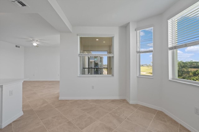 12180 Wellen Golf St Unit 302, Venice, FL 34293 - unfurnished room with plenty of natural light, a ceiling fan, light tile patterned flooring, and baseboards