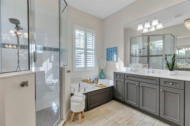 bathroom with a garden tub, wood finish floors, vanity, visible vents, and a shower stall