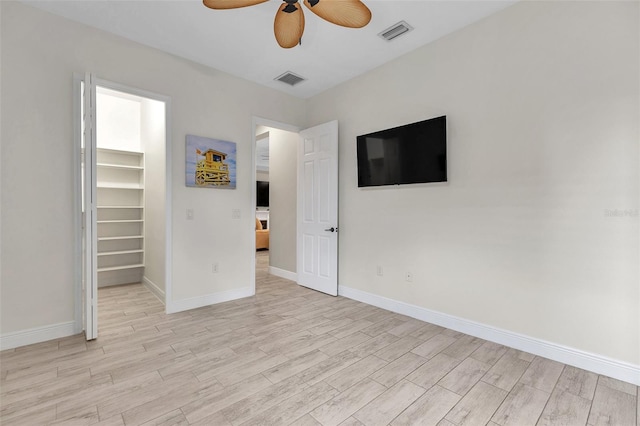 interior space with light wood-style floors, ceiling fan, visible vents, and baseboards