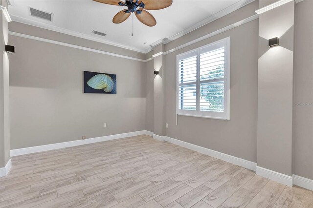 unfurnished room with visible vents, crown molding, baseboards, and wood finished floors