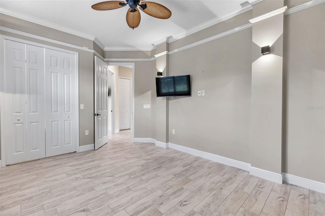 unfurnished room featuring light wood finished floors, ceiling fan, baseboards, and crown molding