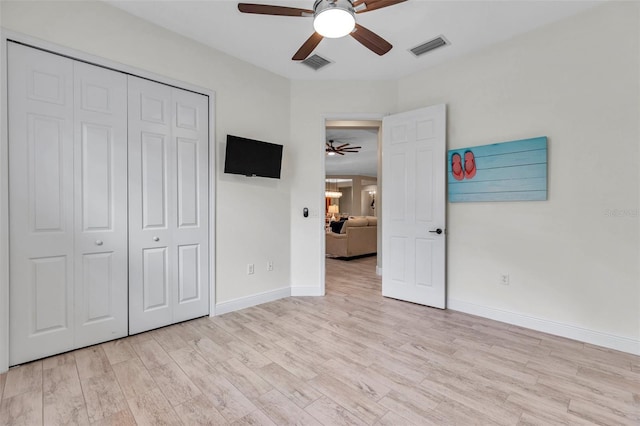 unfurnished bedroom featuring a closet, visible vents, baseboards, and light wood finished floors