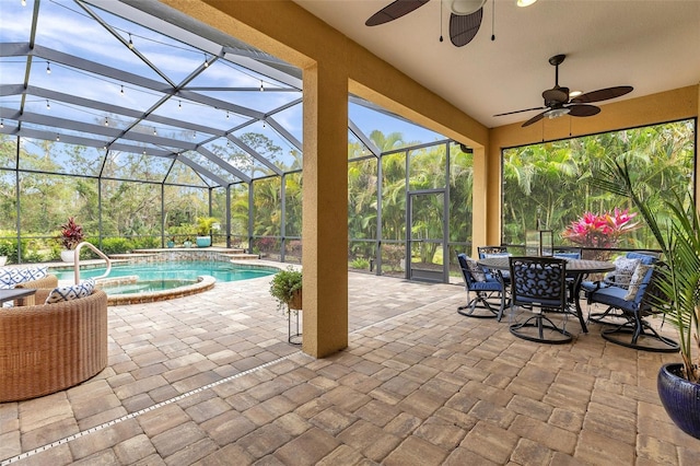 view of patio with glass enclosure, outdoor dining space, a pool with connected hot tub, and a ceiling fan