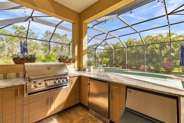 view of patio featuring glass enclosure, exterior kitchen, area for grilling, and an outdoor pool