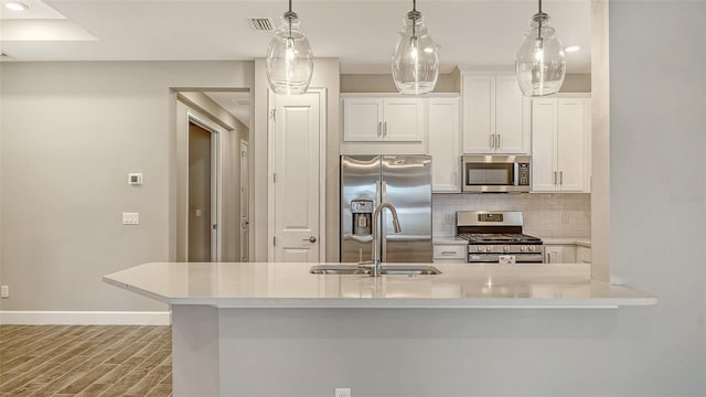 kitchen with baseboards, decorative backsplash, appliances with stainless steel finishes, white cabinetry, and a sink