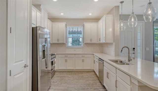 kitchen with white cabinets, backsplash, stainless steel appliances, and a sink