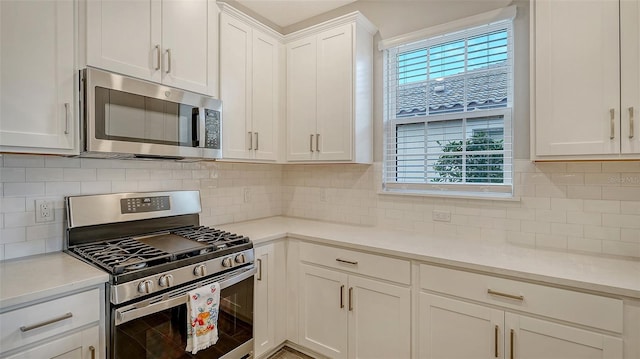 kitchen featuring stainless steel appliances, a wealth of natural light, light countertops, and white cabinetry