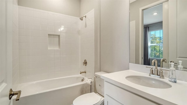 bathroom with toilet, a textured wall, vanity, and shower / bathing tub combination