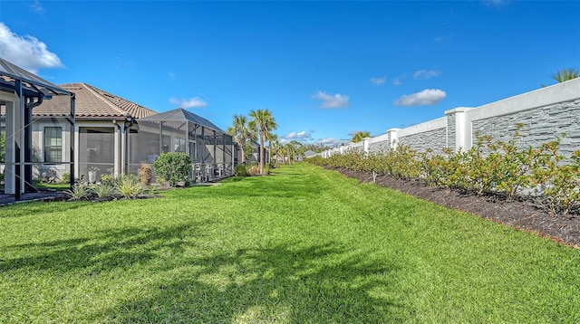 view of yard featuring a lanai and fence