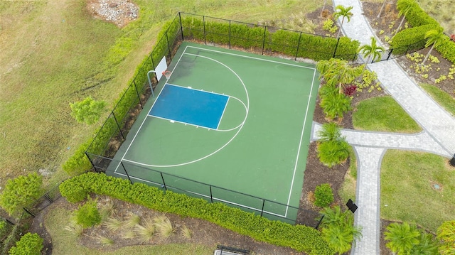 view of basketball court featuring community basketball court, a lawn, and fence