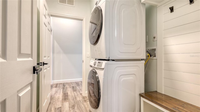 6433 Blue Grosbeak Cir, Lakewood Ranch, FL 34202 - laundry area featuring stacked washer / dryer, visible vents, baseboards, laundry area, and light wood-style flooring