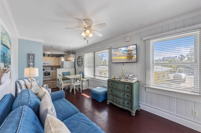 living area featuring a ceiling fan, baseboards, crown molding, and hardwood / wood-style floors