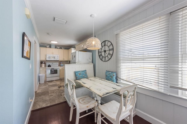 dining area with light wood-type flooring, plenty of natural light, and crown molding