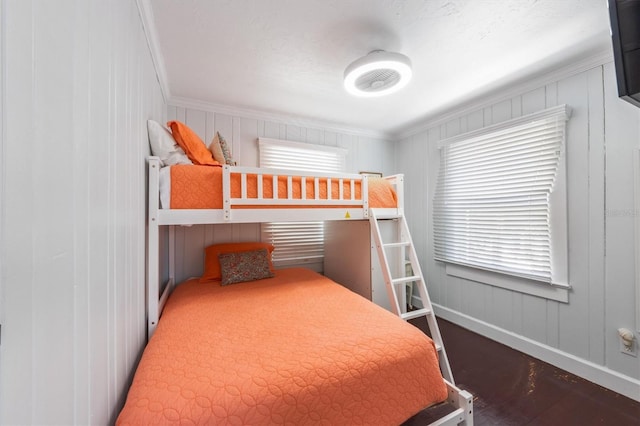 bedroom featuring multiple windows, baseboards, and wood finished floors