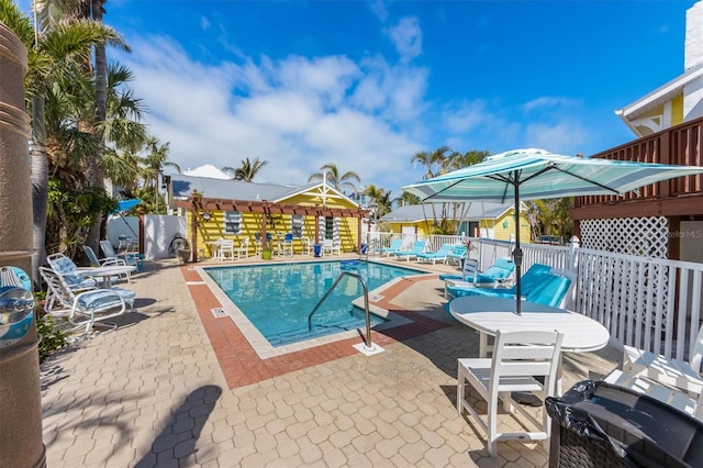 community pool with a patio area and fence