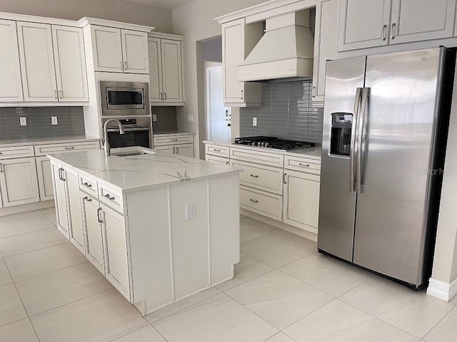 kitchen featuring appliances with stainless steel finishes, light tile patterned floors, custom exhaust hood, and tasteful backsplash