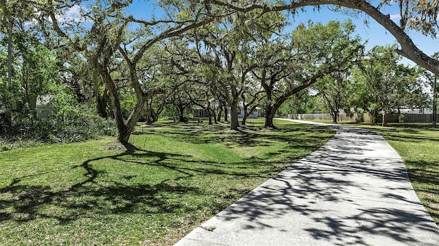 view of community featuring a yard and fence