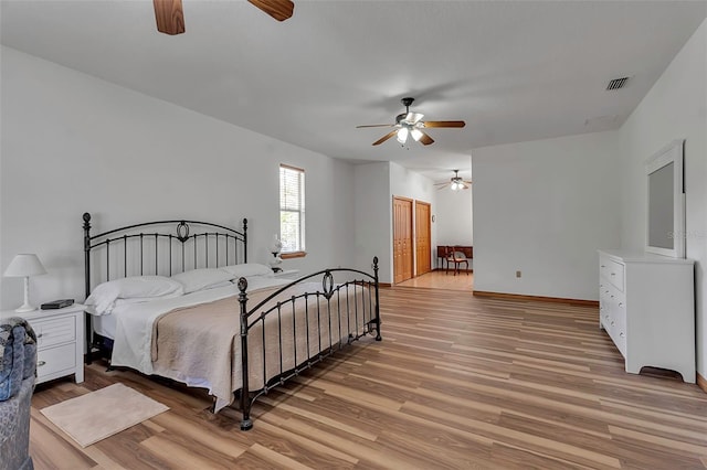 bedroom with visible vents, baseboards, light wood-style floors, and ceiling fan