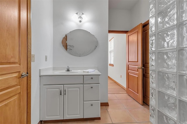 bathroom with baseboards, vanity, and tile patterned flooring