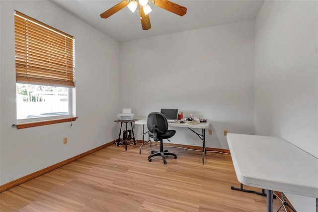 office featuring a ceiling fan, light wood-type flooring, and baseboards