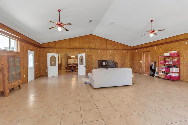 living room with wooden walls, ceiling fan, and vaulted ceiling