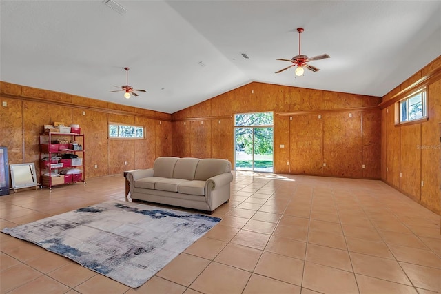 living area with a wealth of natural light, a ceiling fan, and lofted ceiling