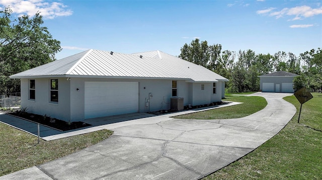 rear view of property with central air condition unit, stucco siding, metal roof, and a yard