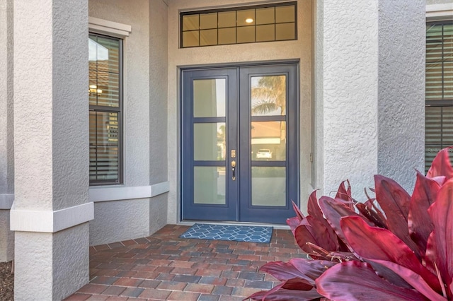 property entrance with french doors and stucco siding