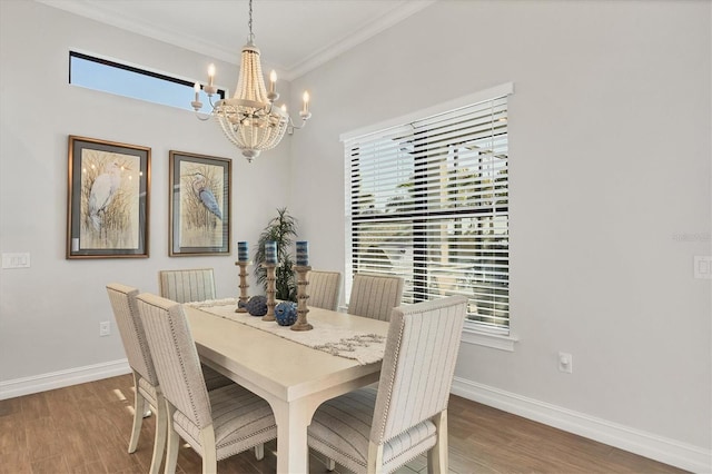 dining space featuring crown molding, plenty of natural light, wood finished floors, and baseboards