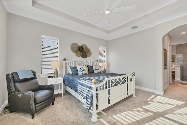 bedroom featuring visible vents, arched walkways, a raised ceiling, and baseboards