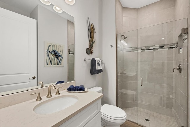 full bathroom with a shower stall, toilet, and vanity