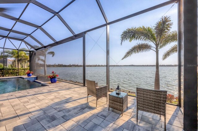 view of patio featuring an outdoor pool, glass enclosure, and a water view