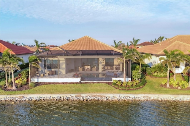 back of property featuring a patio area, a water view, and a tile roof