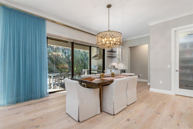 dining room featuring light wood finished floors, baseboards, ornamental molding, and a chandelier