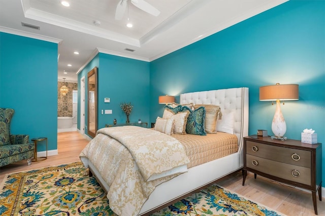 bedroom with ornamental molding, a raised ceiling, visible vents, and wood finished floors