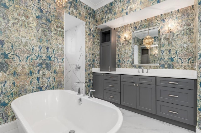 full bath featuring marble finish floor, a freestanding bath, vanity, and wallpapered walls