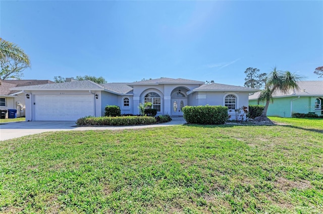 ranch-style house featuring a garage, a front lawn, concrete driveway, and stucco siding